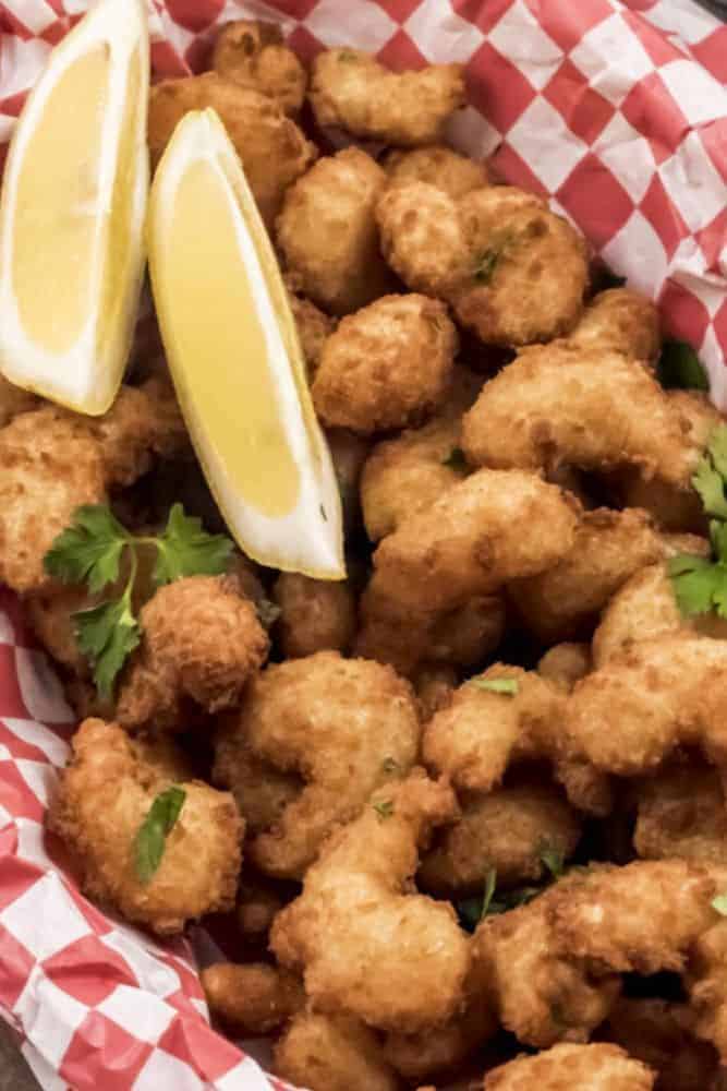 Air Fryer Popcorn Shrimp in a red basket with lemon wedges