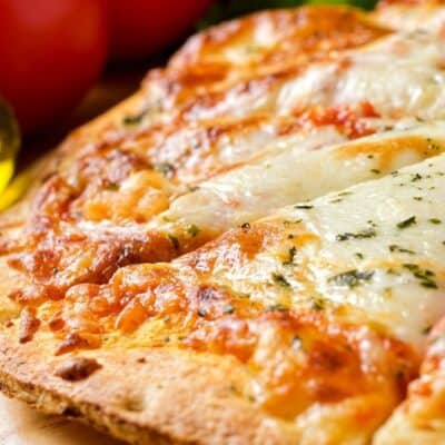 Closeup of whole pizza cut into slices