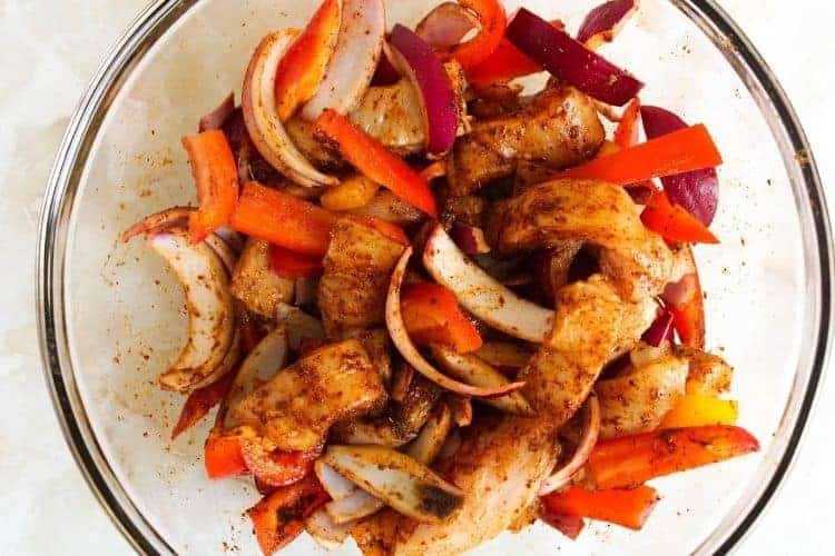 Air Fryer Meat and Bell Peppers with Onions and chili lime seasoning inside a clear bowl
