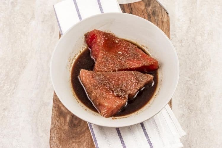 Ahi tuna steaks with marinade in a bowl