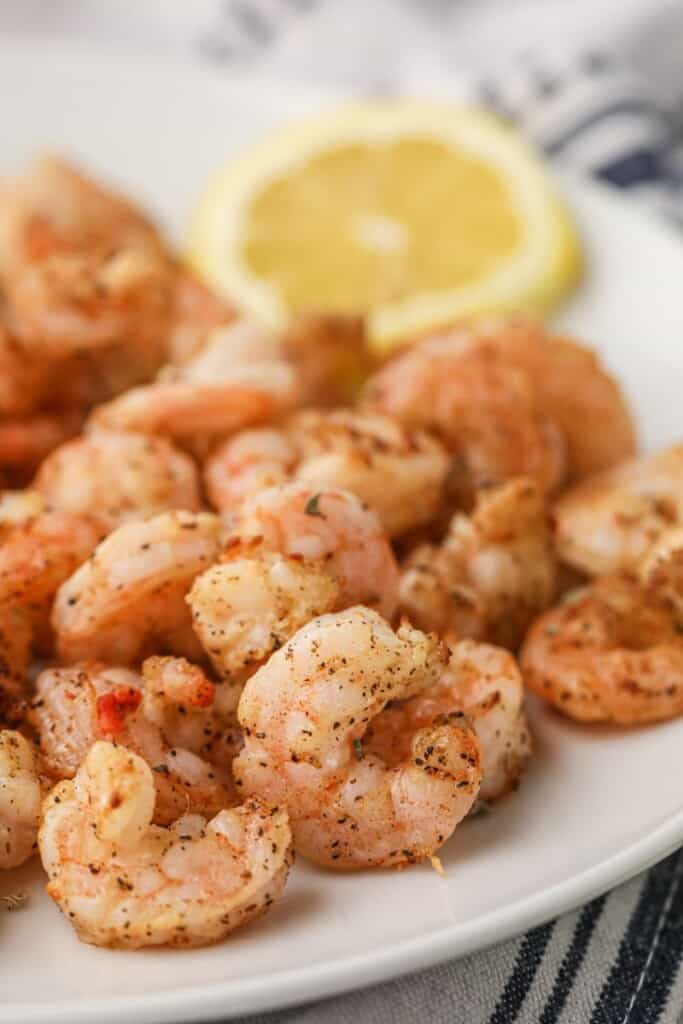 Air Fryer Shrimp on a white plate with lemon slice