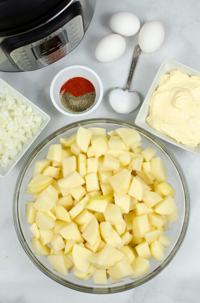 Ingredients for potato salad in bowls and measuring spoons with Instant Pot in the back