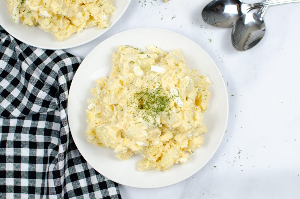 Instant Pot Potato Salad on white plate with black and white plaid napkin to side