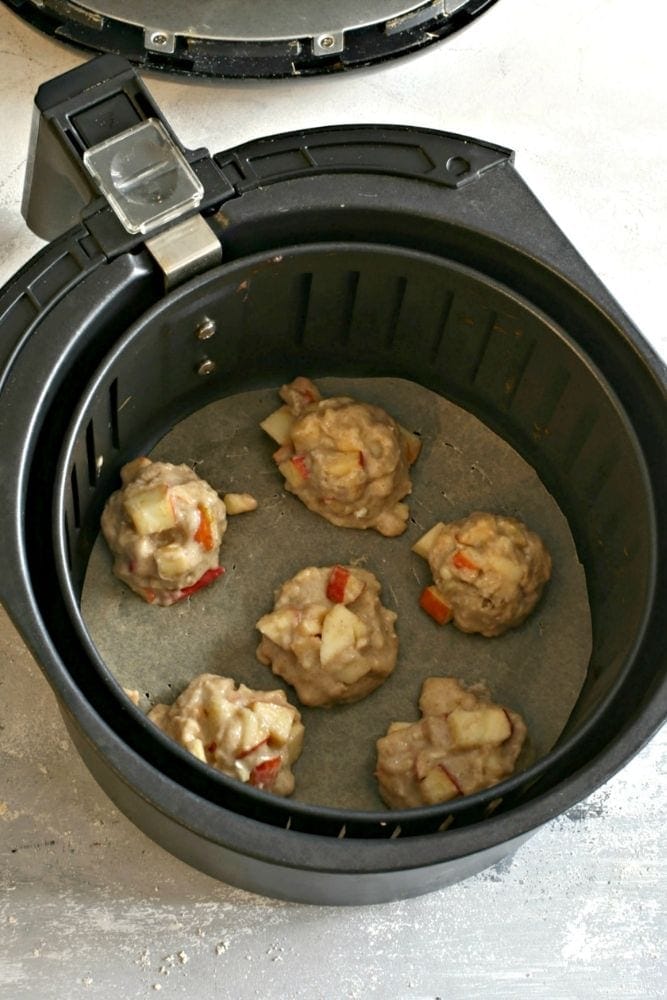 Apple Fritters in Air Fryer Uncooked with parchment paper round on bottom