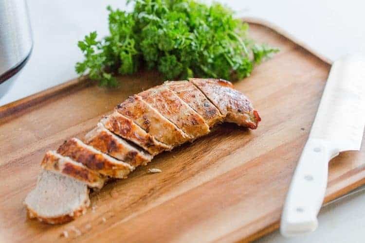 Sliced air fryer pork tenderloin on a cutting board