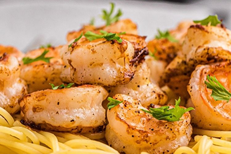 Closeup of air fryer shrimp on top of pasta