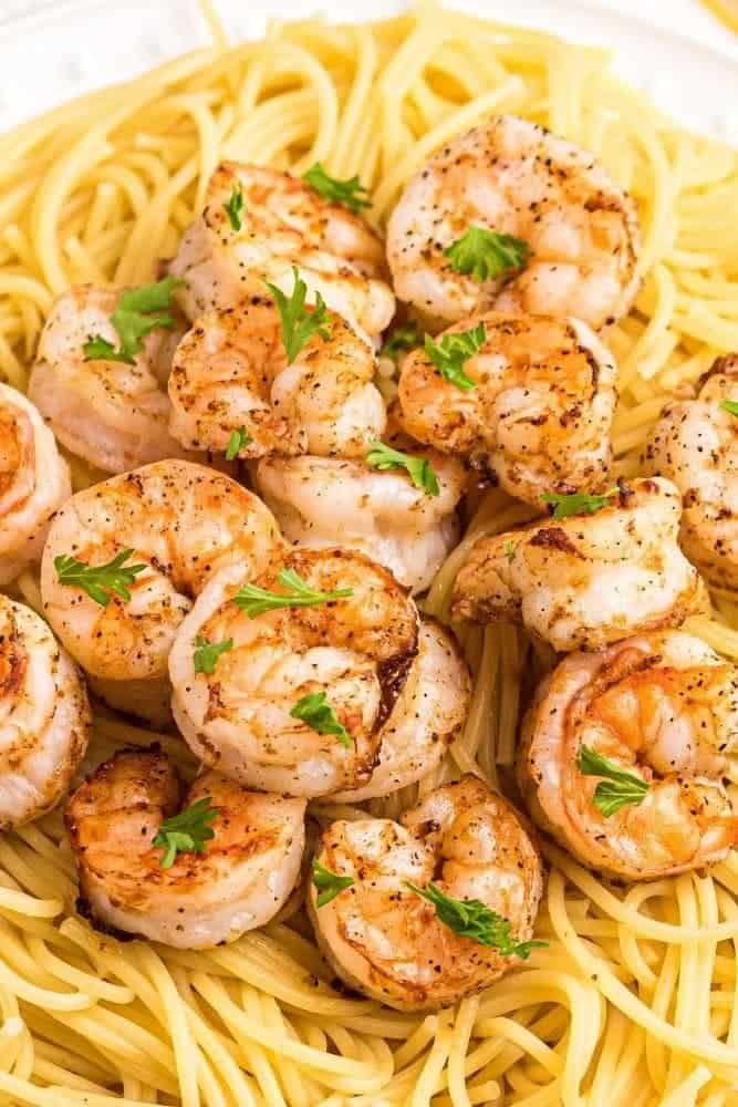 Air Fryer Shrimp on top of spaghetti on a white plate