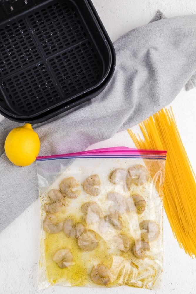 Raw shrimp in Ziploc bag with lemon pepper ingredients 