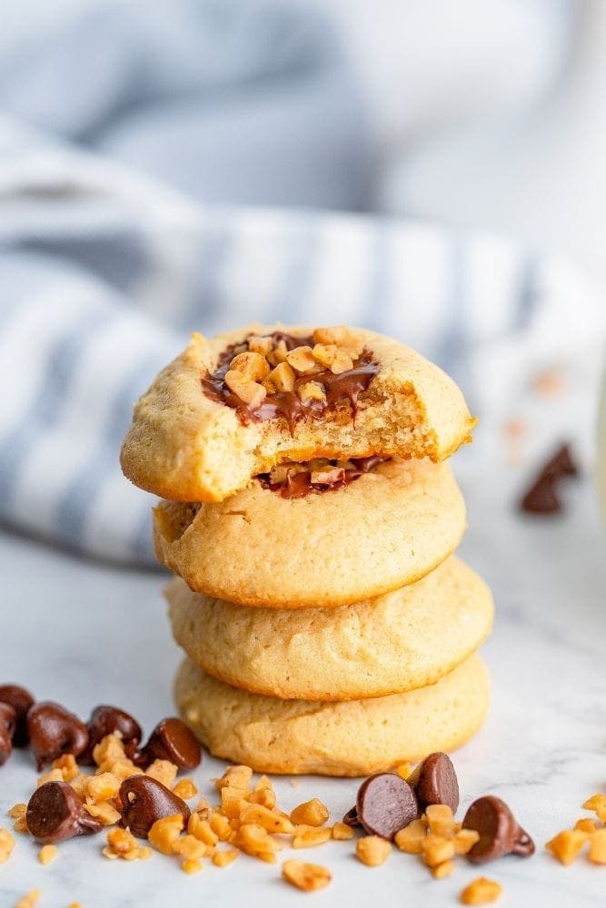 Toffee Cookies Stacked on top of each other with a bite out of the top cookie