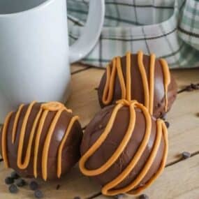 Hot Chocolate Balls drizzled with peanut butter on a table