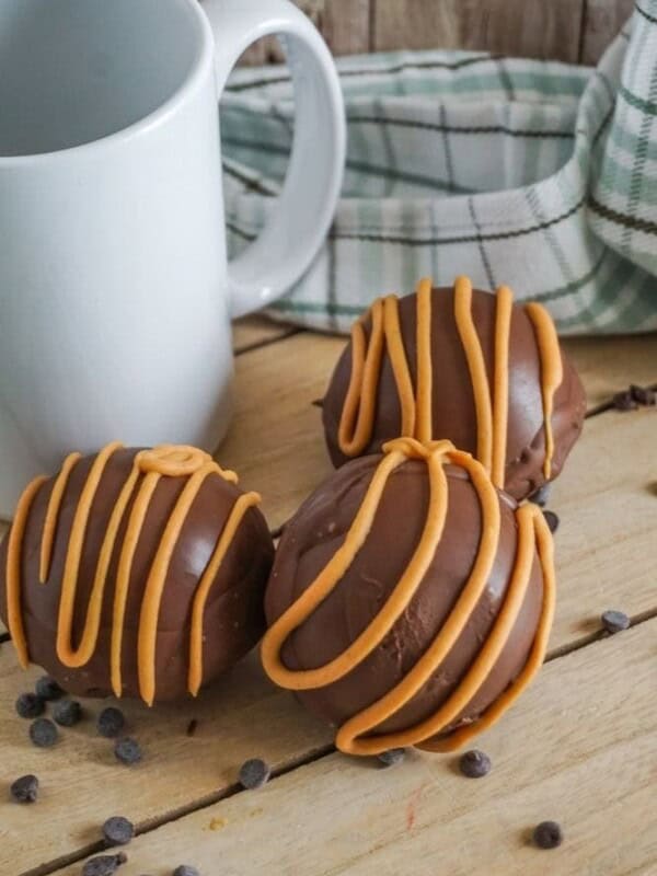 Hot Chocolate Balls drizzled with peanut butter on a table