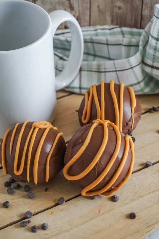 Hot Chocolate Balls drizzled with peanut butter on a table