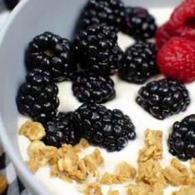 Closeup of almond milk yogurt in a bowl with blackberries, raspberries and granola