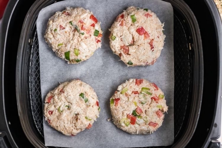 Raw crab cake patties inside the air fryer