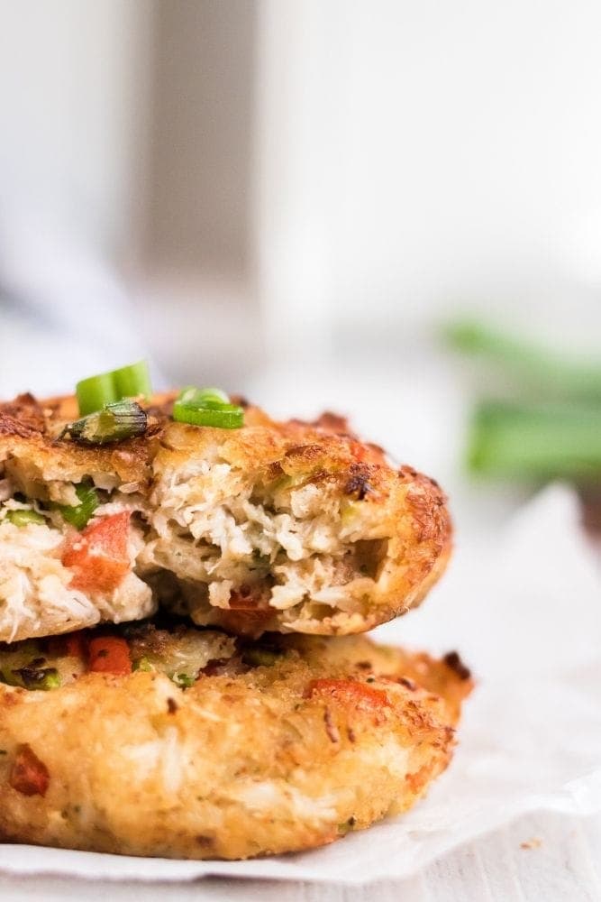 Closeup of stacked crab cakes with a bite taken out of top one