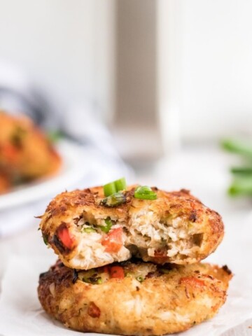 Air Fryer Crab Cakes stacked on each other with a bite taken out of the top one