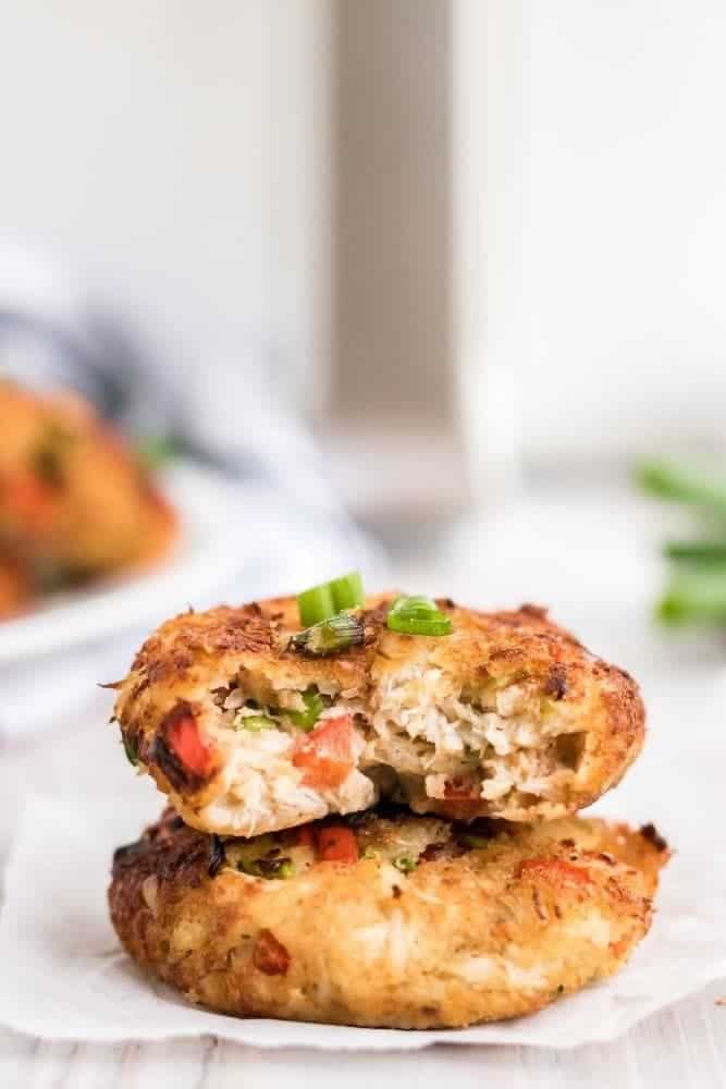 Air Fryer Crab Cakes stacked on each other with a bite taken out of the top one