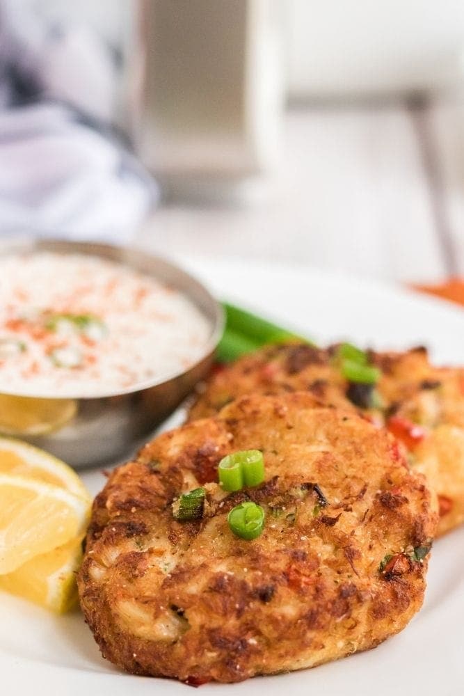 Air Fryer Crab Patties on a white plate with green garnish