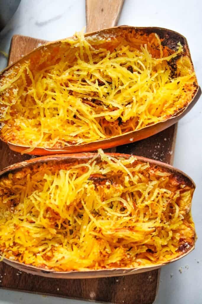 Cooked air fryer spaghetti squash halves cut open with strands pulled 