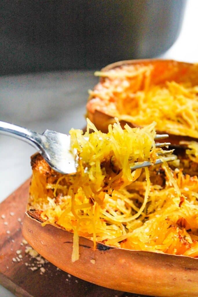 Spaghetti Squash halve with a fork pulling out a bite of squash