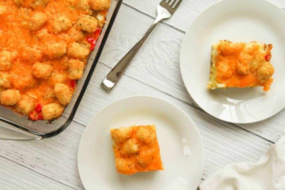 Tater Tot Casserole without meat in a pan with slices on white plates to the side