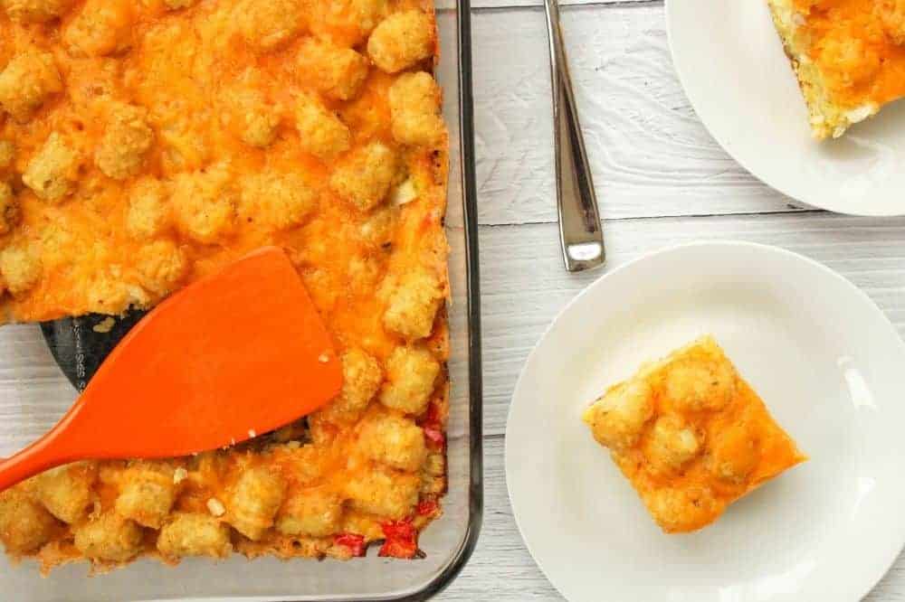 Breakfast Tater Tot Casserole without soup in a 13x9 pan and slices cut out on white plates