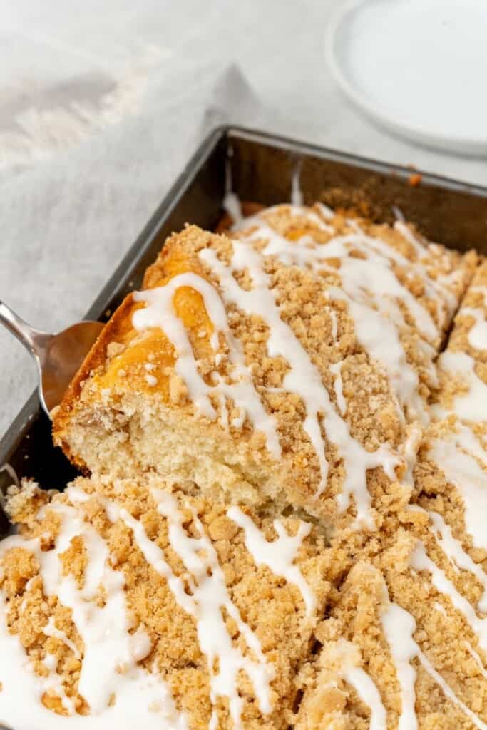 A slice of coffee cake being taken out of a pan