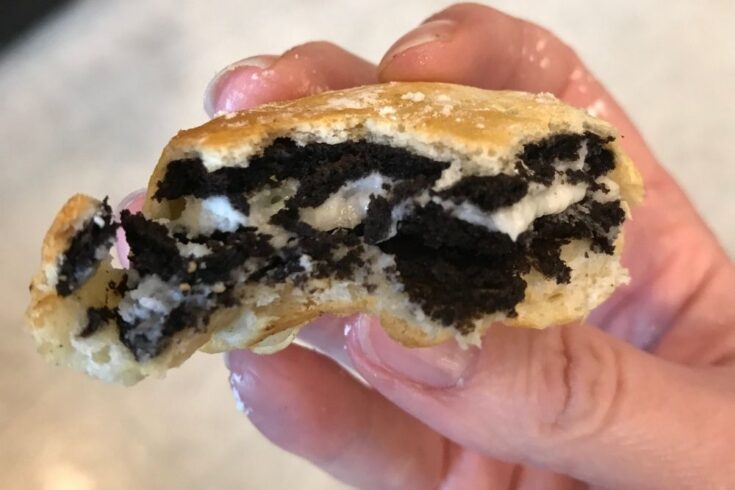 Air Fryer Oreo held in a hand with bite taken out of it