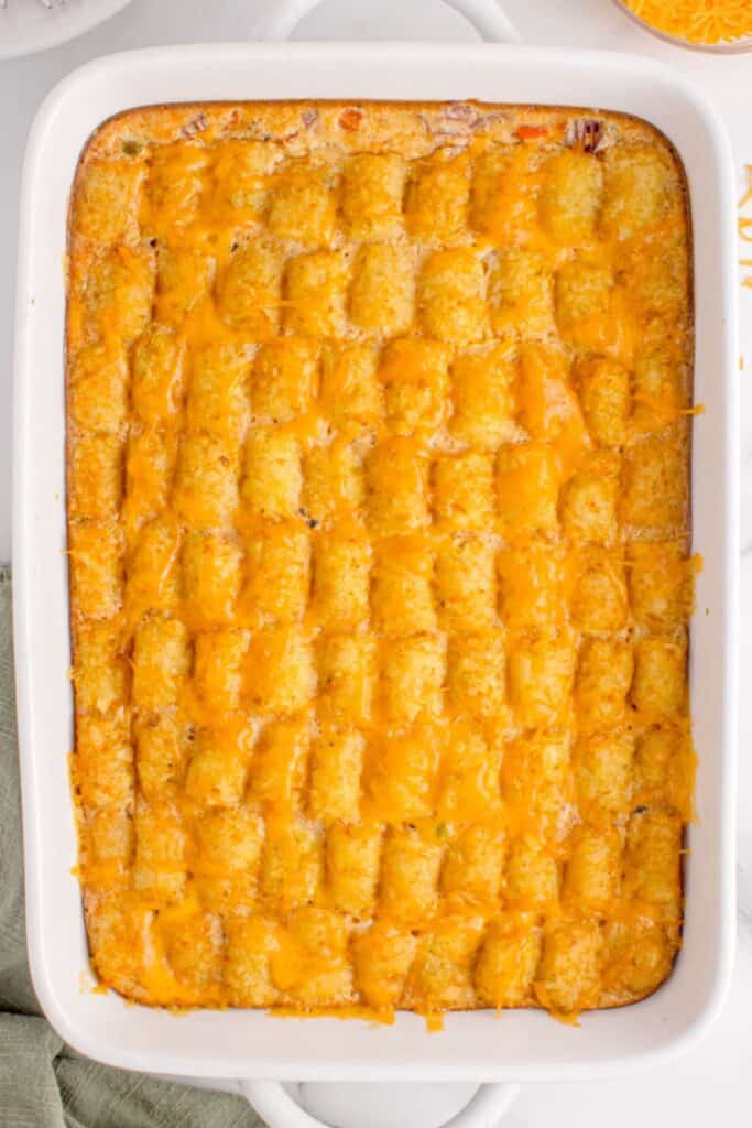 Close up of the cooked vegetarian tater tot casserole in a baking dish showing the cheesiness on top.