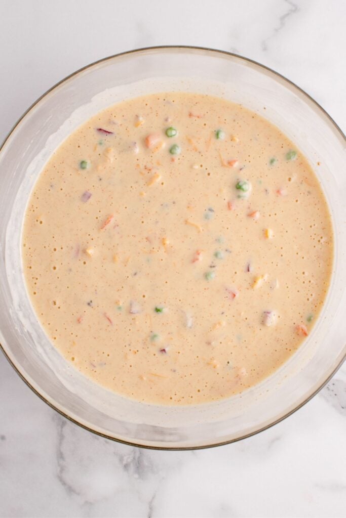 Egg mixture mixed in a glass bowl to a make a tater tot casserole recipe.