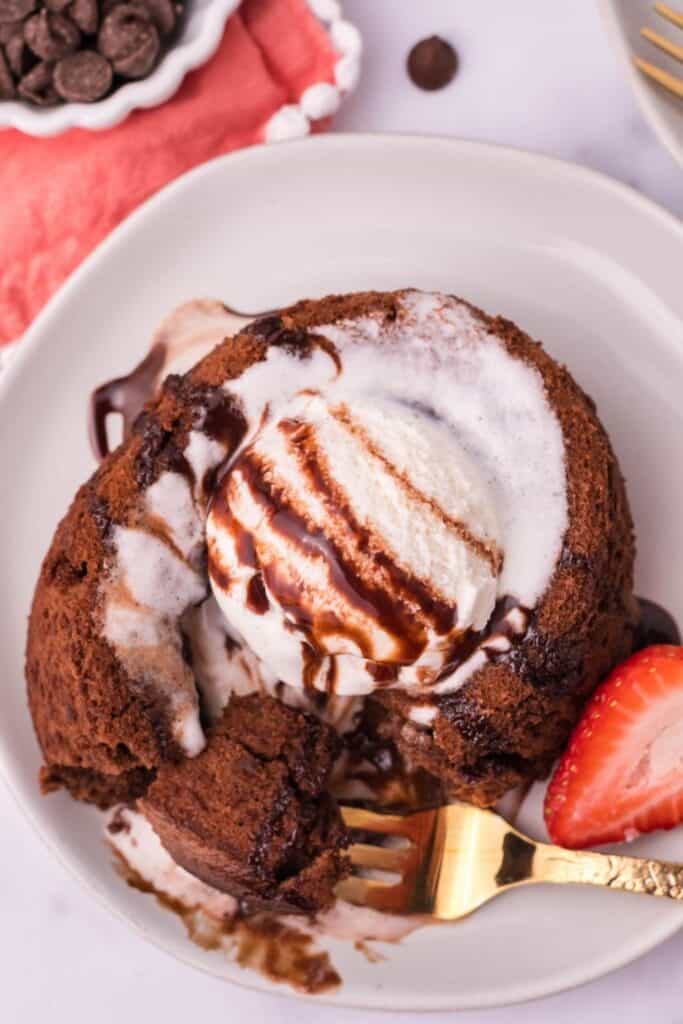 Overtop view of air fryer Nutella lava cake with vanilla ice cream and chocolate syrup