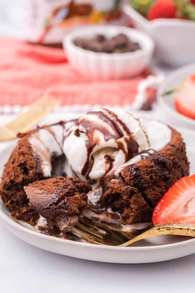 Molten Lava Cake with vanilla ice cream and chocolate syrup with piece missing and Nutella center oozing out