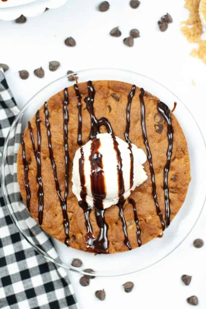 Air Fryer Cookie Cake for One from overhead with ice cream anf syrup drizzled on top