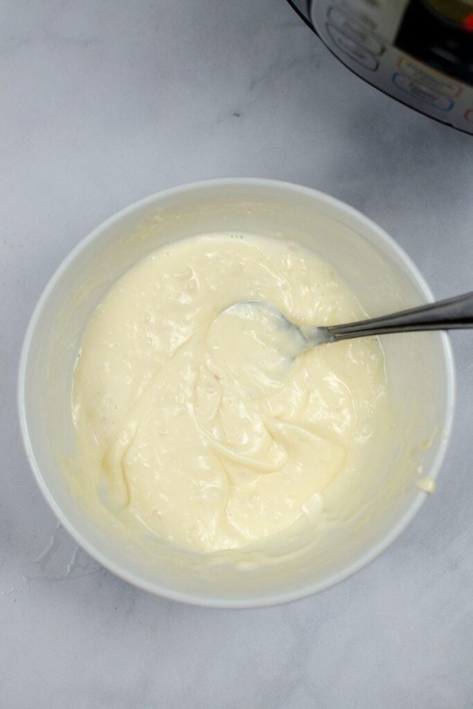 Garlic Aioli sauce mixed up in a white bowl with a spoon in it