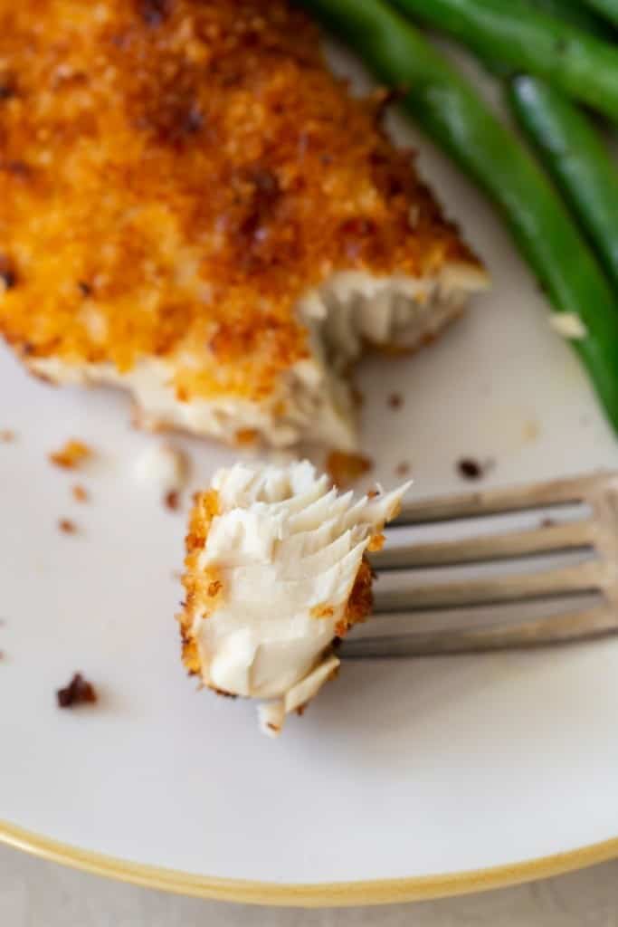 Closeup of Air Fryer Breaded Mahi Mahi piece on a fork showing the flakiness of the fish