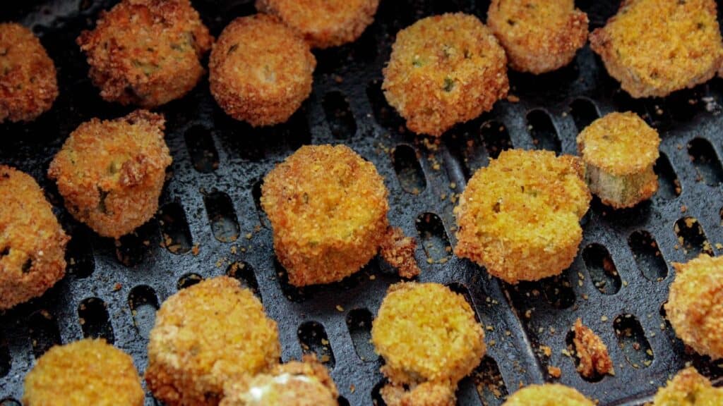 Cooked okra in an air fryer basket.