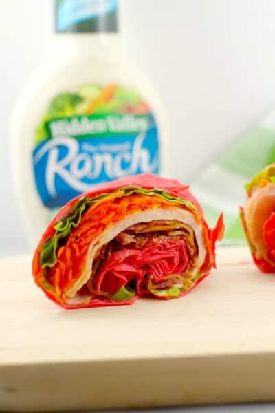 Turkey bacon wrap close up with a bottle of ranch in the background.