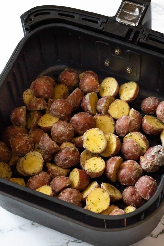 Raw ranch potatoes inside air fryer basket
