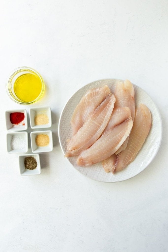 Ingredients needed to make air fryer tilapia on a white background