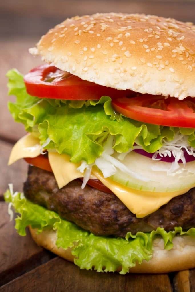 Hamburger that was cooked from frozen in the air fryer on a sesame bun with lettuce, tomato, onion, and cheese