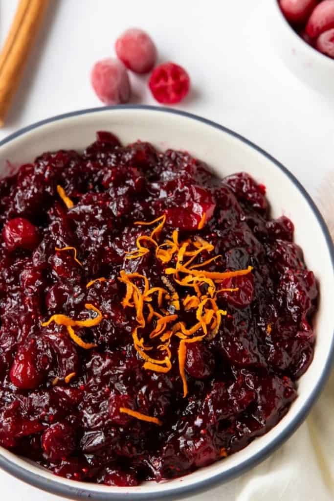 Closeup good cranberry orange sauce in a bowl with orange zest on top