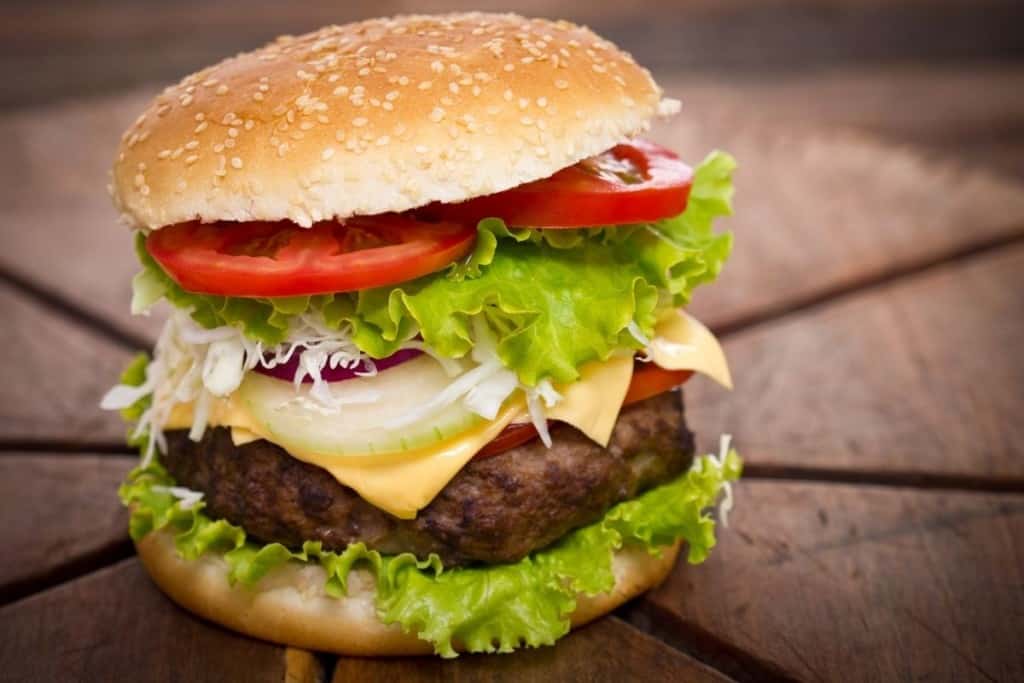 Cooked air fryer frozen hamburger on a sesame bun with condiments