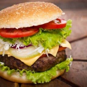 Cooked air fryer frozen hamburger on a sesame bun with condiments