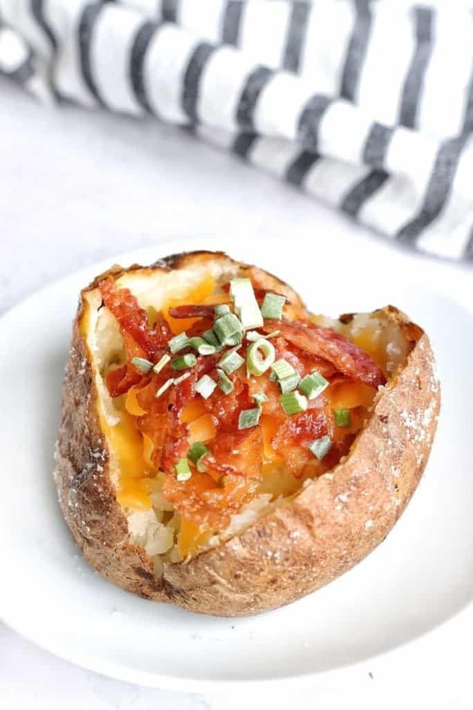 Baked potato topped with bacon, cheese, and chives