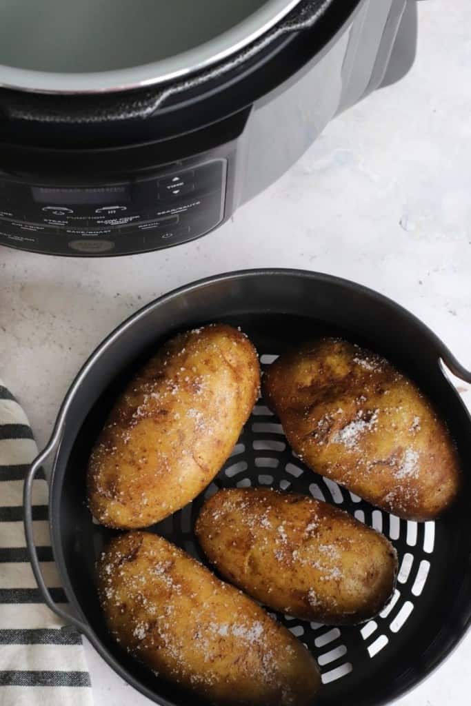 Baked potatoes inside Ninja Foodi air fryer basket