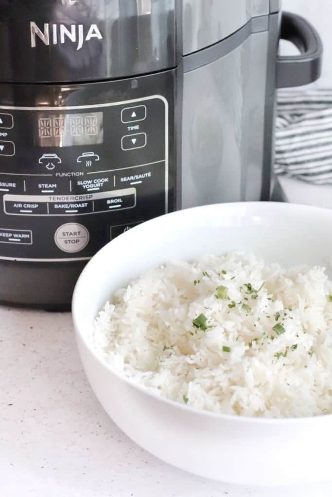 Rice in a white bowl in front of the Ninja Foodi