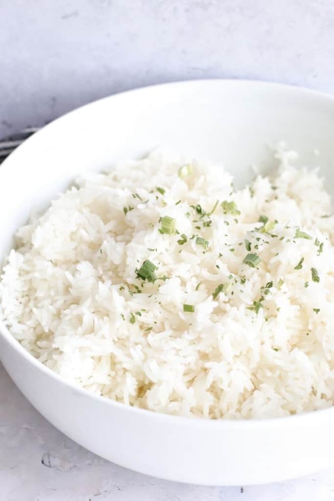 Jasmine Rice in a white bowl with parsley pieces on top