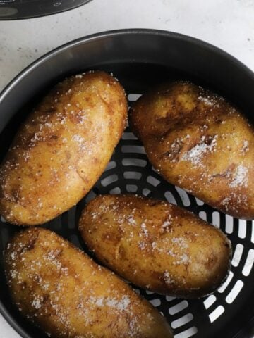 Baked potatoes inside Ninja Foodi air fryer basket