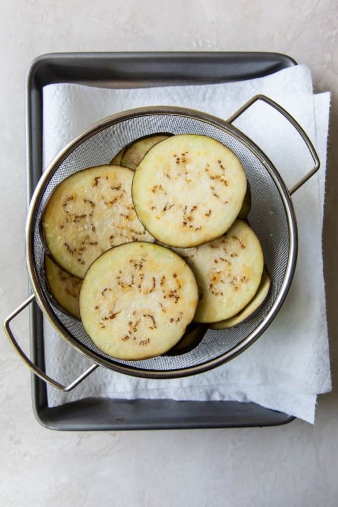 Eggplant slices in a colander after being salted