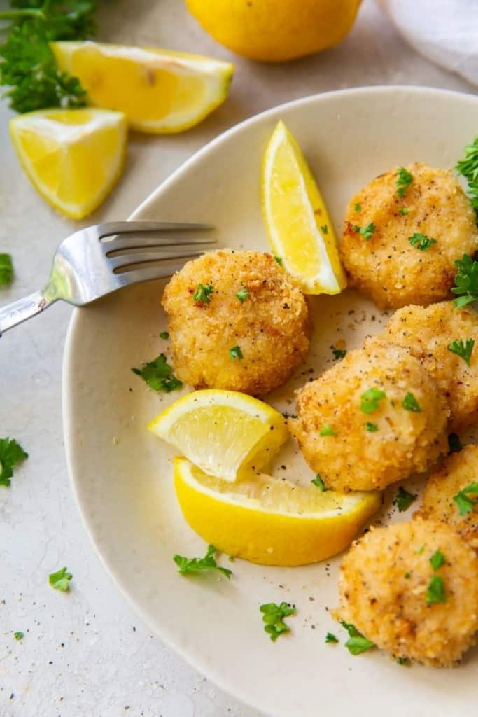 Air Fryer Scallops breaded and plated with a fork and lemon slices